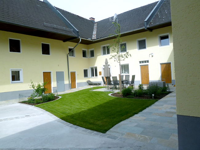 Innenhof Bauernhaus modern, verlegte Natursteinplatten als Platz für die Gartengarniture